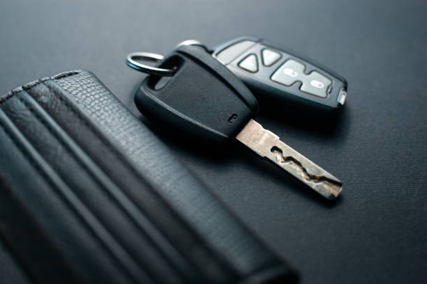 istock Black leather wallet with car key on a black background 1147510340