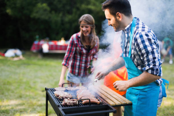 istock Young happy people grilling outdoors and smiling 1147510630