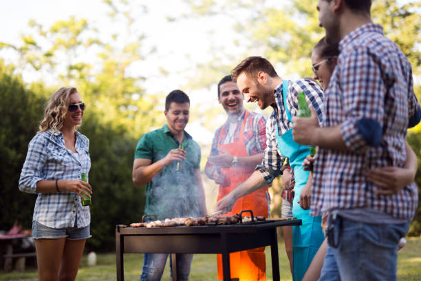 istock Young and happy people grilling outdoors in nature 1147510634
