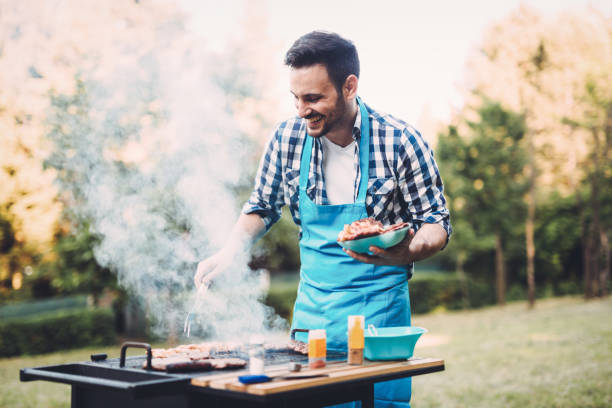 istock Happy male preparing bbq meat in nature 1147510677