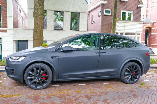 Tesla Model X electric SUV in matte black parked on the street in Zwolle, Netherlands. The Model X is a fast SUV that accelerates from zero to 60 miles per hour in 3.2 seconds and is equipped with an autopilot system.