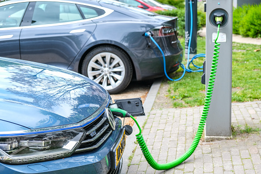 Volkswagen Passat GTE and Tesla Model S electric cars at an electric vehicle charging station in the city center of Zwolle, The Netherlands.