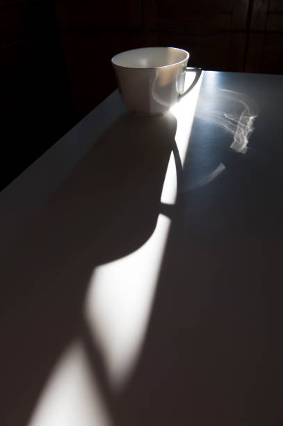 istock cup on a white table in the shade and light 1147513072