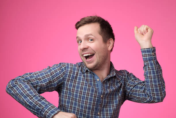 istock Young caucasian man is dancing on pink background 1147514952
