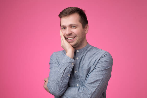 istock Smiling young caucasian man putting his hand to his chin 1147515521