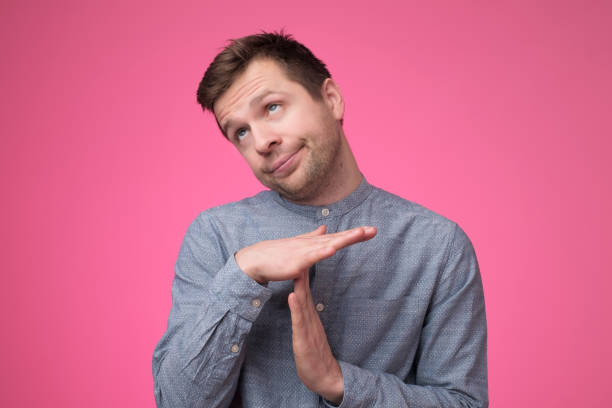 istock Young man giving showing time out with hands gesture isolated on pink background 1147516846