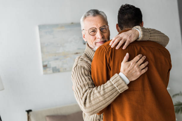 istock happy senior man in glasses smiling while hugging son 1147518321