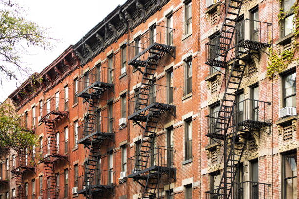 vue rapprochée des immeubles d’appartements de style new-yorkais avec escaliers d’urgence le long de la rue mott dans le quartier chinatown de manhattan, new york, états-unis. - brooklyn sign new york city queens photos et images de collection