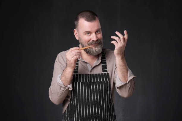 istock man showing cinnamon spices. Advice how to cook. 1147520139