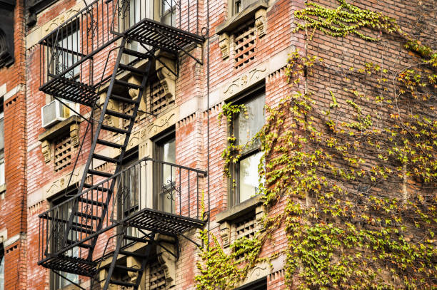 vue rapprochée des immeubles d’appartements de style new-yorkais avec escaliers d’urgence le long de la rue mott dans le quartier chinatown de manhattan, new york, états-unis. - brooklyn sign new york city queens photos et images de collection