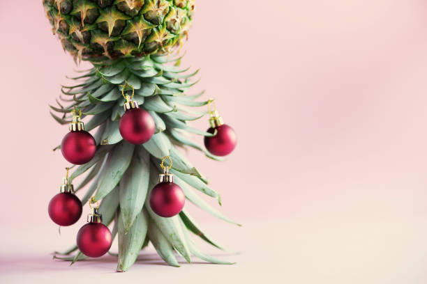 istock Creative Christmas tree made of pineapple and red bauble on pink background, copy space. Greeting card, decoration for new year party. Holiday concept. 1147521038