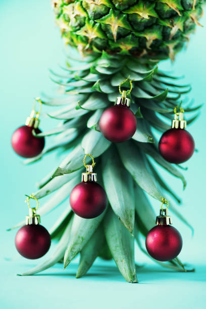 istock Creative Christmas tree made of pineapple and red bauble on blue background, copy space. Greeting card, decoration for new year party. Holiday concept. 1147521049