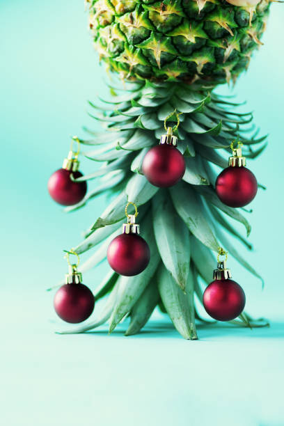 istock Creative Christmas tree made of pineapple and red bauble on blue background, copy space. Greeting card, decoration for new year party. Holiday concept. 1147521054