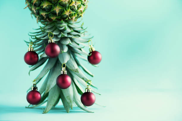 istock Creative Christmas tree made of pineapple and red bauble on blue background, copy space. Greeting card, decoration for new year party. Holiday concept. 1147521100