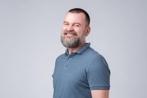 istock Confident senior man with beard in blue t-shirt smiling 1147521561