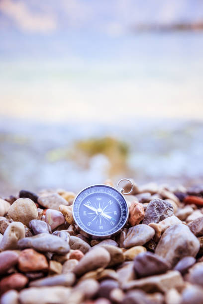 istock Navigation concept: Compass is lying on the beach near the sea 1147523369