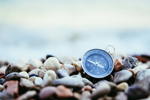concept de navigation: compass est couché sur la plage près de la mer - compass guidance business direction photos et images de collection