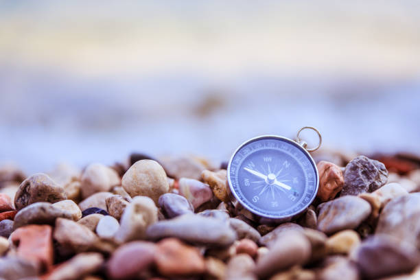 istock Navigation concept: Compass is lying on the beach near the sea 1147523395