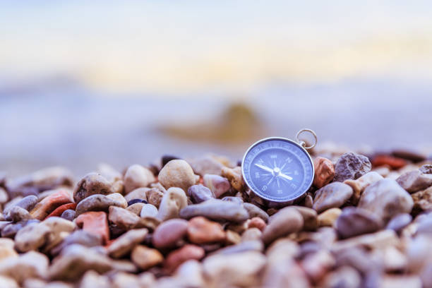 istock Navigation concept: Compass is lying on the beach near the sea 1147523405