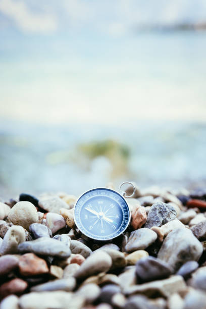 istock Navigation concept: Compass is lying on the beach near the sea 1147523434