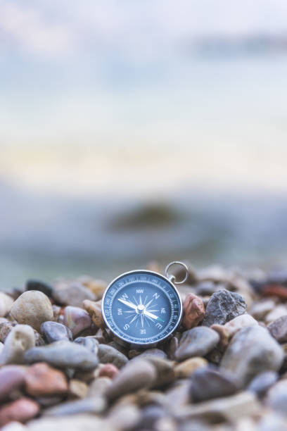 istock Navigation concept: Compass is lying on the beach near the sea 1147523486