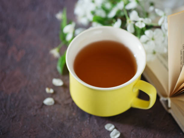 istock Spring blooming branch of cherry , a Cup of tea and a book 1147524686