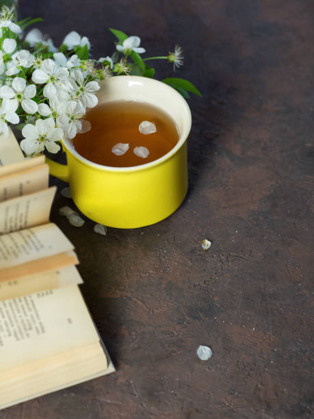 istock Spring blooming branch of cherry , a Cup of tea and a book 1147524698
