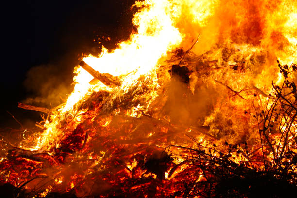 istock Large bonfire, burning and glowing with soft flames, sparkles flying agains the dark sky. Glowing wood silhouettes. Walpurgis night, traditional witch burning and spring welcoming ritual. 30 April. 1147526309