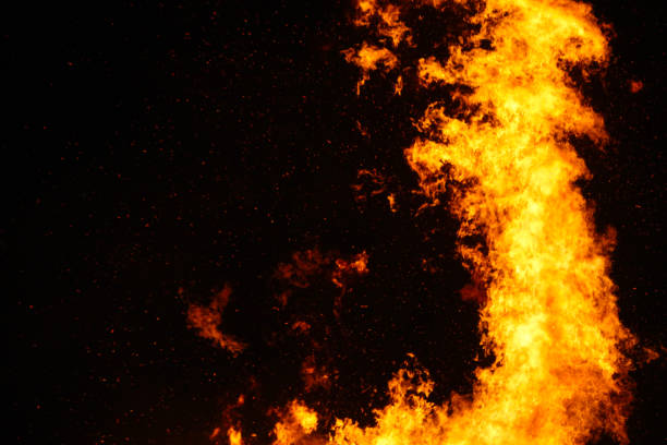 istock Large bonfire, burning and glowing with soft flames, sparkles flying agains the dark sky. Glowing wood silhouettes. Walpurgis night, traditional witch burning and spring welcoming ritual. 30 April. 1147526954
