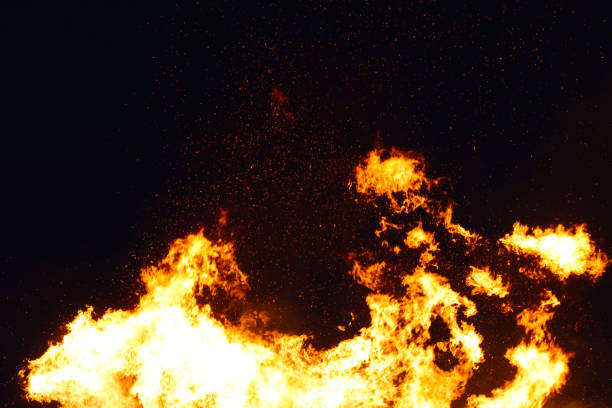 istock Large bonfire, burning and glowing with soft flames, sparkles flying agains the dark sky. Glowing wood silhouettes. Walpurgis night, traditional witch burning and spring welcoming ritual. 30 April. 1147528036