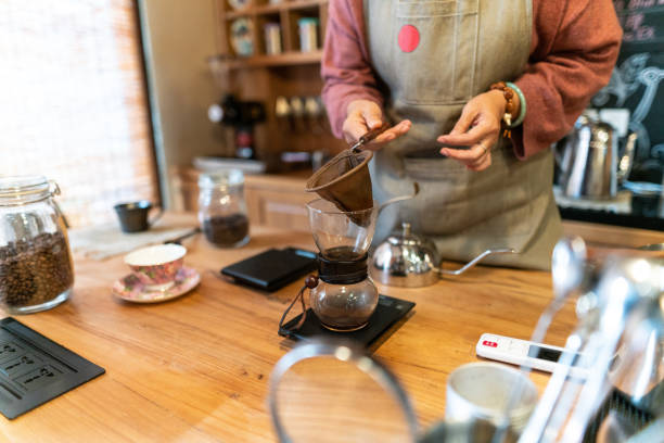istock Unrecognizable woman making coffee in coffee lab 1147531704