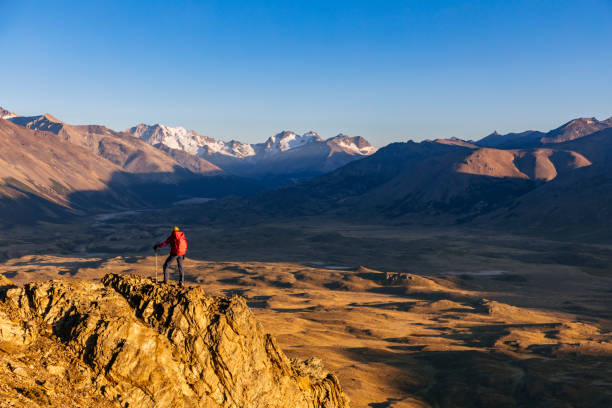 Man enjoying the view while mountaineering in Los Andes mountain range. Lifestyle image of a person trekking trails outdoors as a recreational pursuit and sport activity.
