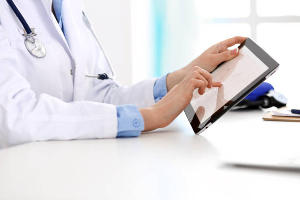 istock Doctor working table. Woman physician using tablet computer while sitting in hospital office close-up. Healthcare, insurance and medicine concept 1147534353