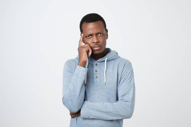 istock Handsome young african american man looking up with thoughtful and skeptical expression 1147534414
