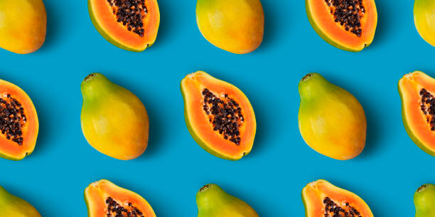 Papaya fruit seamless pattern on blue color background Papaya fruit seamless pattern on blue color background, flat lay, top view papaya stock pictures, royalty-free photos & images