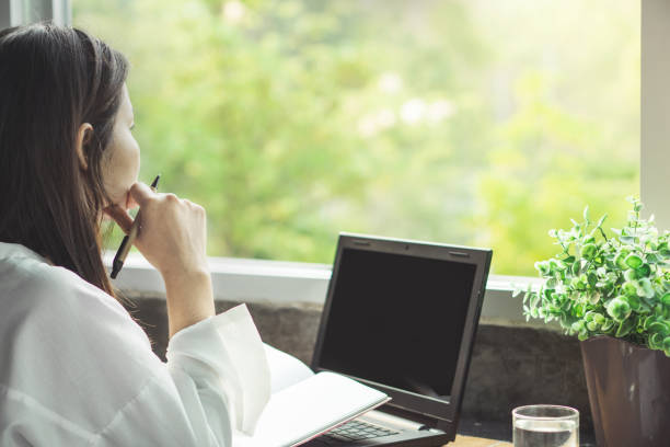 istock female freelancer working from home hand holding pen thinking 1147537603