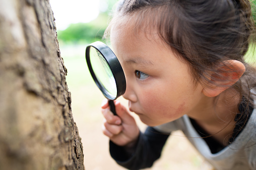 Girl looking with magnifying glass