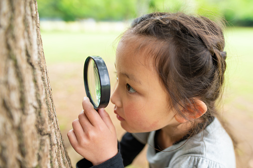 Girl looking with magnifying glass