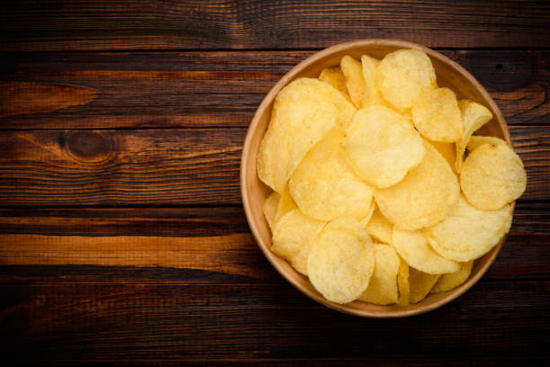 istock Potato chips in bowl on dark wooden table 1147539832