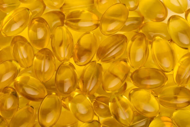 istock Transparent yellow pills capsules macro background 1147540279