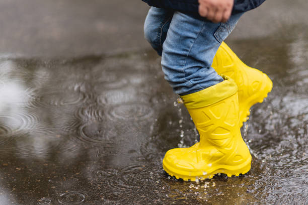 비를 지나면 어린 소년이 봄에 웅덩이를 걷는다. - puddle rain child splashing 뉴스 사진 이미지