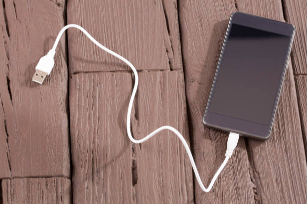 istock Phone with USB cable - Wooden background 1147541659