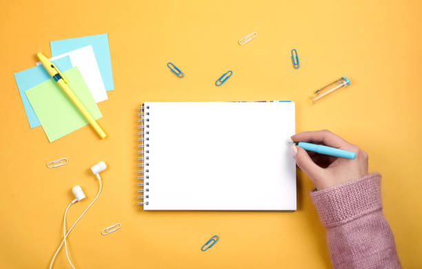 istock Write thoughts and ideas in a clean white notebook on an orange background 1147542996