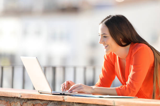 istock Happy entrepreneur entering data in a laptop on balcony 1147543007