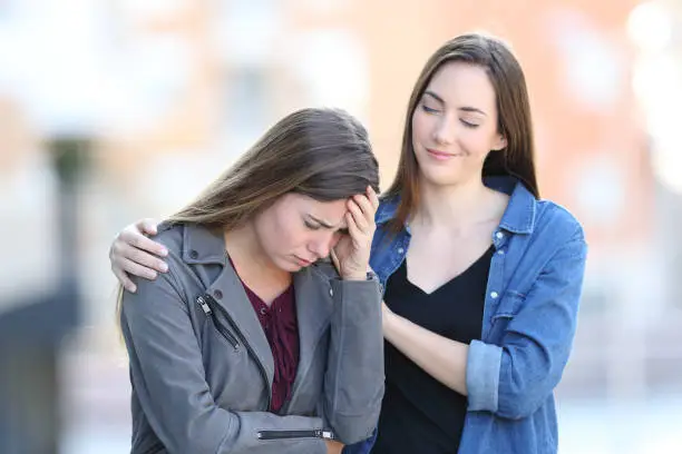 Hypocrite bad woman comforting her sad friend