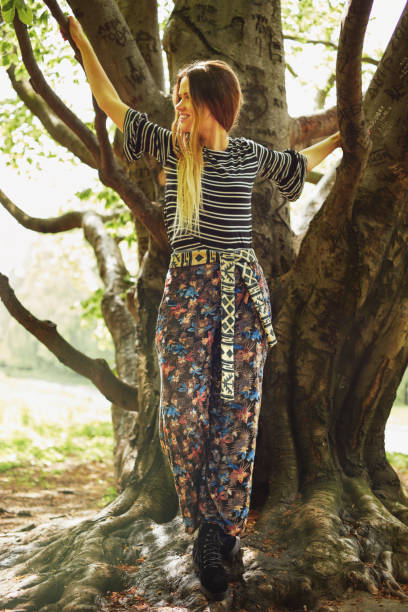 istock Young woman climbing a tree in the park 1147544569