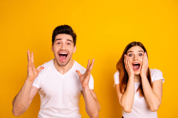 feche acima da foto surpreendente ela ela ele ele seu par de mãos braços levantou ar gritar inacreditável sorte dia da claque de futebol match desgaste casual branco t-shirts outfit isolado fundo amarelo - child excitement awe fun - fotografias e filmes do acervo