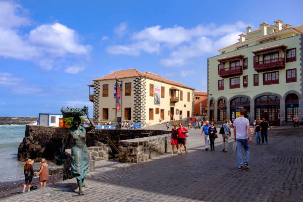 Tenerife, Canary Islands - Puerto de la Cruz: the dock The bronze statue of a young woman selling fish welcomes tourists at the dock of Puerto de la Cruz, a city and a very popular tourist destination in the northwest part of the island of Tenerife. It was sculpted in 2008 by Julio Nieto for the Lions Club of Puerto de la Cruz. puerto de la cruz tenerife stock pictures, royalty-free photos & images