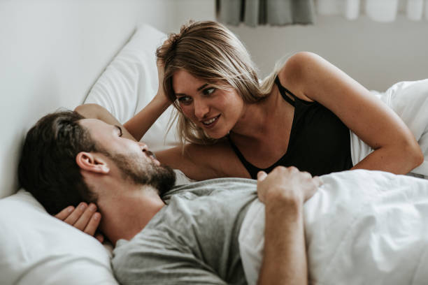 romantischer moment: glückliches paar verliebt im bett-stock-bild - sexual activity sex couple sensuality stock-fotos und bilder