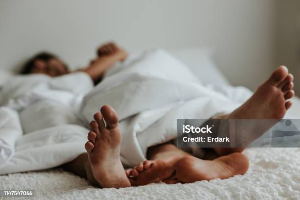Feet Of A Couple In A Bed Stock Image Stock Photo - Download Image Now - Couple - Relationship, Bed - Furniture, Sensuality